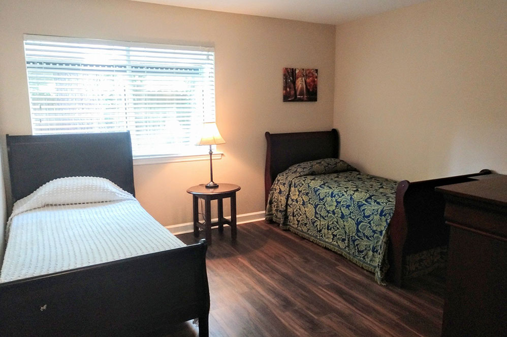 Bedroom with two beds, nightstand and large window